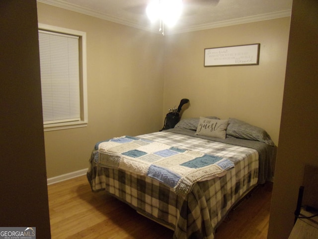 bedroom featuring crown molding, ceiling fan, and wood-type flooring