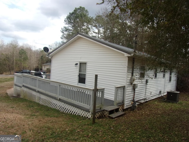 back of house featuring a yard, a deck, and central air condition unit