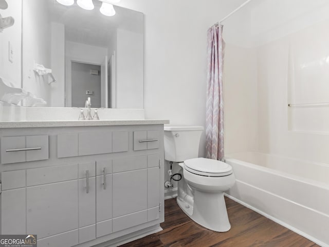 full bathroom featuring hardwood / wood-style flooring, vanity, shower / tub combo, and toilet