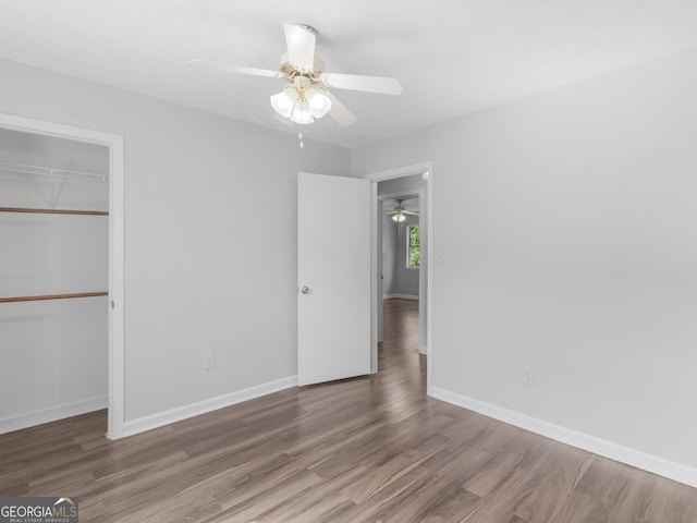 unfurnished bedroom with hardwood / wood-style floors, ceiling fan, and a closet