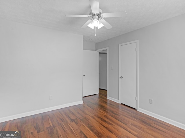 unfurnished room featuring ceiling fan, dark hardwood / wood-style floors, and a textured ceiling