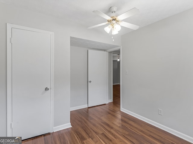 unfurnished bedroom featuring dark wood-type flooring, ceiling fan, a closet, and a textured ceiling