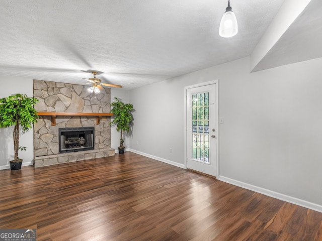 unfurnished living room featuring ceiling fan, hardwood / wood-style floors, a textured ceiling, and a fireplace