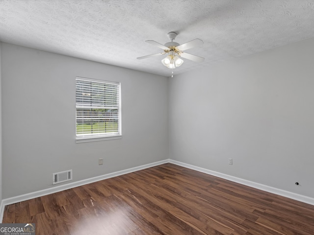 empty room featuring ceiling fan, dark hardwood / wood-style flooring, and a textured ceiling