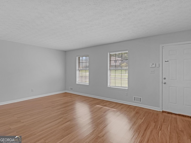 interior space with a textured ceiling and light wood-type flooring