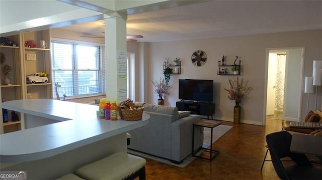 living room featuring ceiling fan and dark parquet floors