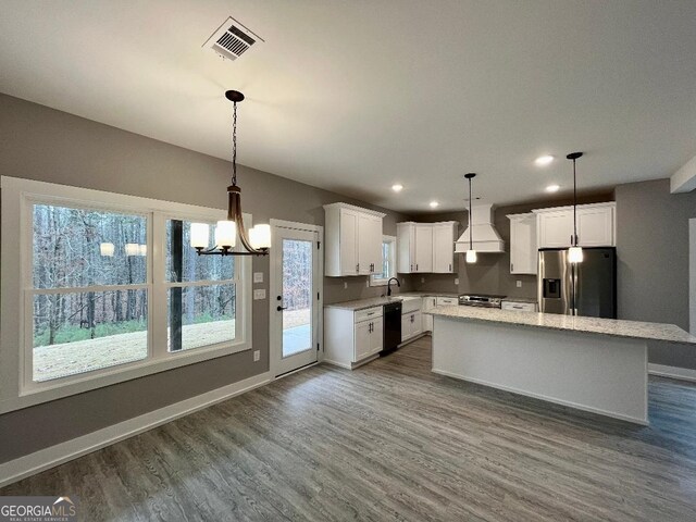 kitchen with white cabinetry, sink, stainless steel range with electric cooktop, black fridge, and custom range hood