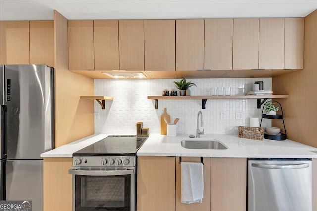 kitchen featuring sink, light brown cabinets, stainless steel appliances, light stone countertops, and decorative backsplash