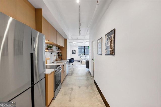 kitchen with track lighting, appliances with stainless steel finishes, and sink