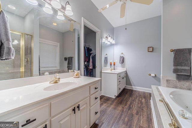 bathroom with shower with separate bathtub, vaulted ceiling, vanity, hardwood / wood-style flooring, and ceiling fan