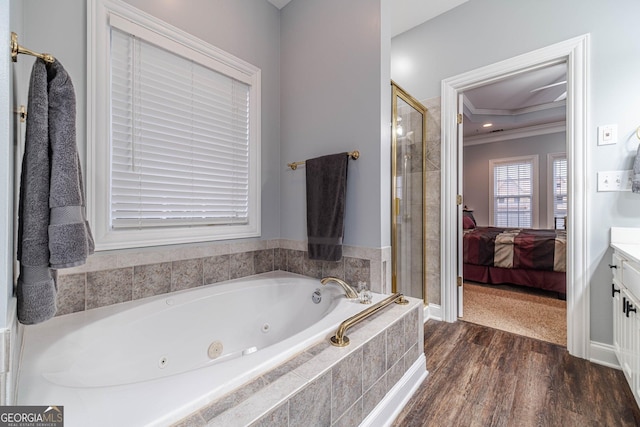 bathroom with independent shower and bath, crown molding, hardwood / wood-style floors, and vanity