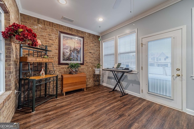 interior space with crown molding, brick wall, and dark hardwood / wood-style flooring