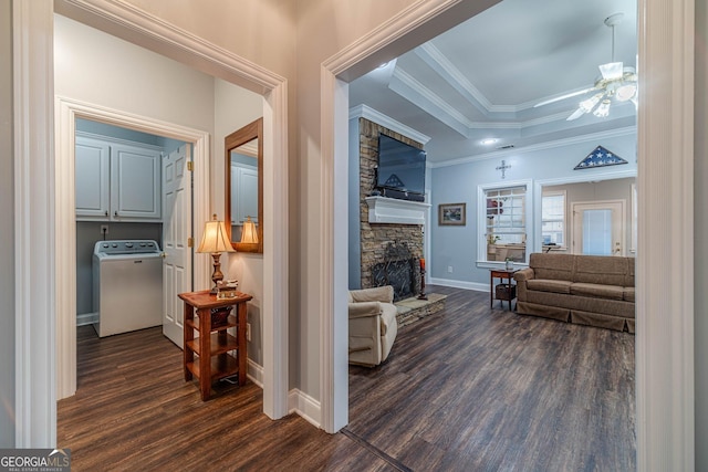 hallway featuring dark hardwood / wood-style flooring, washer / clothes dryer, a tray ceiling, and crown molding