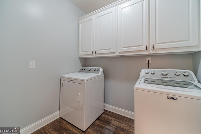 washroom featuring cabinets, washing machine and dryer, and dark hardwood / wood-style floors