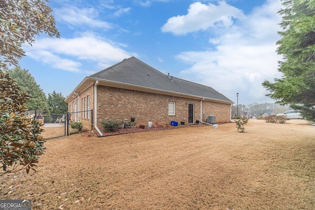 back of house with cooling unit and a yard