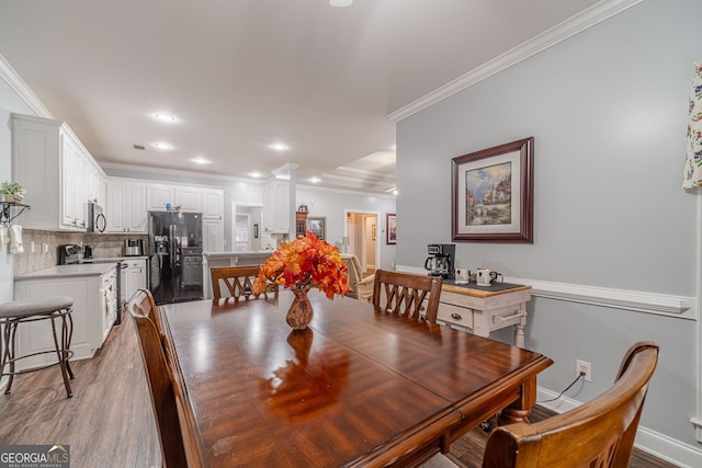 dining room featuring ornamental molding, light hardwood / wood-style floors, and ornate columns