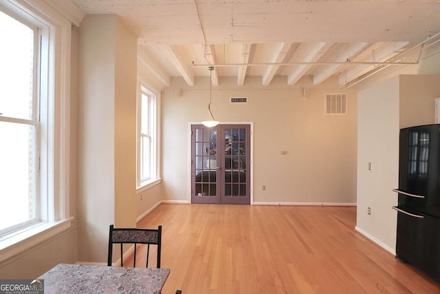 dining area with beamed ceiling, hardwood / wood-style floors, and french doors