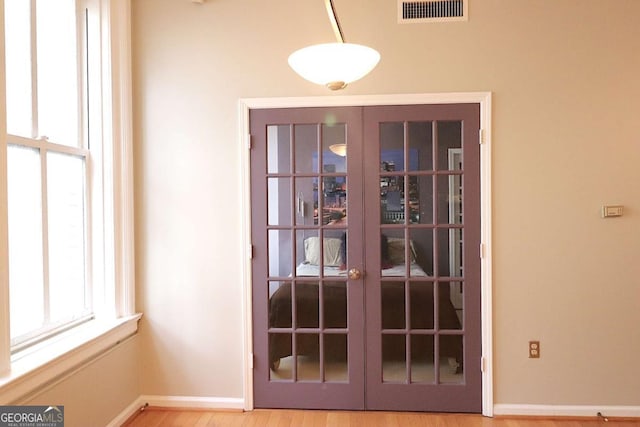 doorway with wood-type flooring and french doors