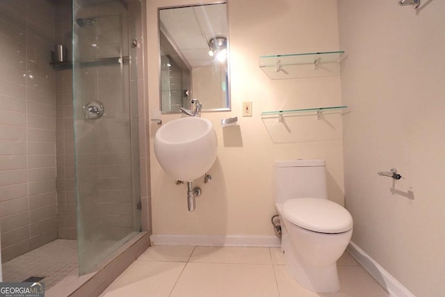 bathroom featuring a shower with door, tile patterned flooring, and toilet