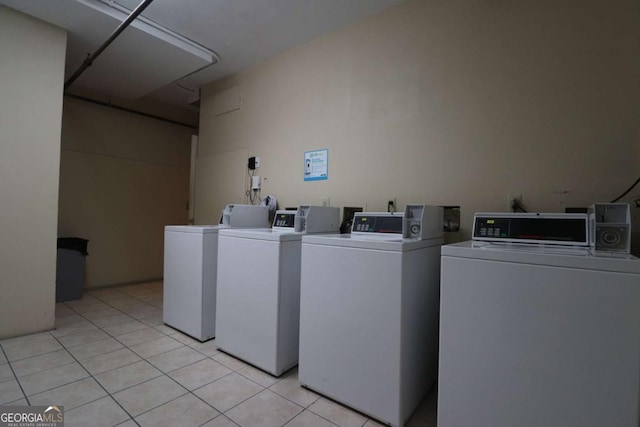 clothes washing area with separate washer and dryer and light tile patterned floors