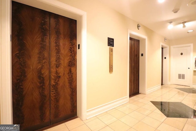 hall with elevator and light tile patterned floors