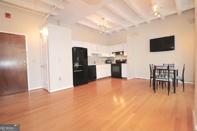 kitchen with light hardwood / wood-style flooring, white cabinetry, tasteful backsplash, black appliances, and beamed ceiling