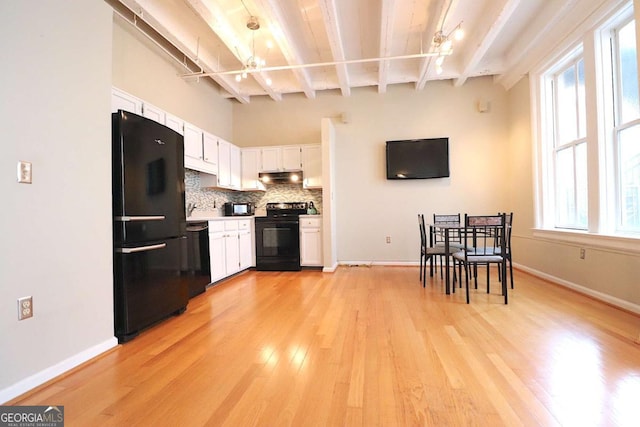 kitchen featuring white cabinetry, backsplash, beam ceiling, a wealth of natural light, and black appliances