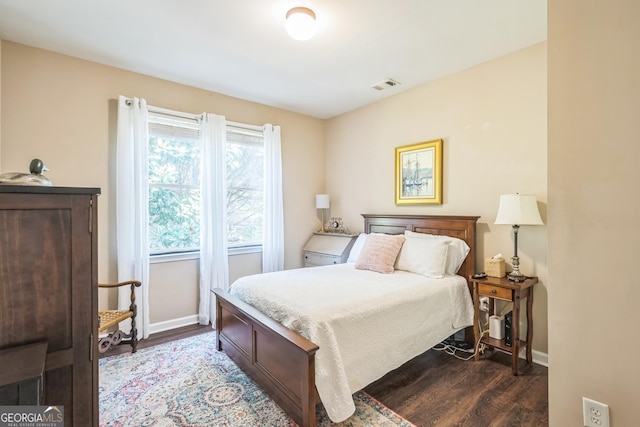 bedroom with dark hardwood / wood-style flooring