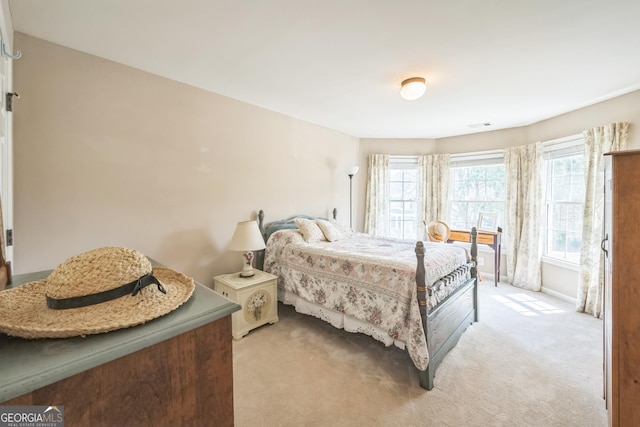 bedroom with light colored carpet and multiple windows