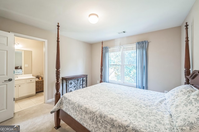 bedroom featuring sink, light colored carpet, and ensuite bathroom