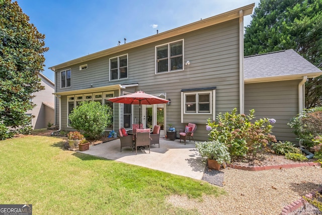 back of property with a yard and a patio area