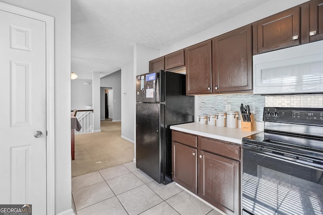 kitchen featuring dark brown cabinetry, a textured ceiling, light colored carpet, decorative backsplash, and black appliances