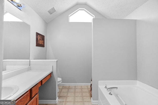 bathroom with lofted ceiling, a bathtub, a textured ceiling, and vanity