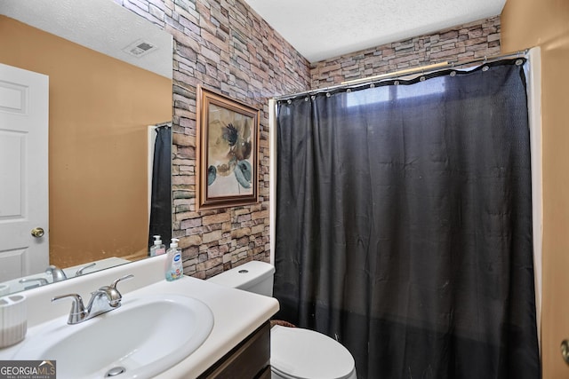 bathroom featuring vanity, toilet, a textured ceiling, and walk in shower