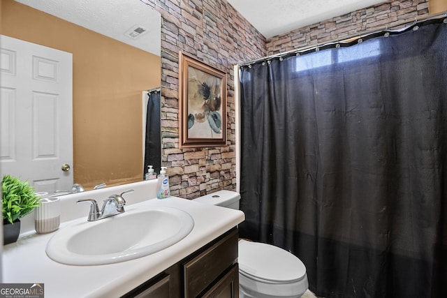 bathroom featuring vanity, toilet, curtained shower, and a textured ceiling