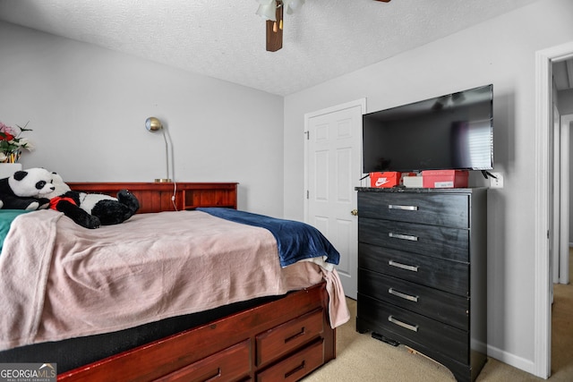 bedroom featuring light carpet, ceiling fan, and a textured ceiling