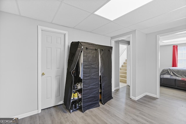 interior space with a drop ceiling and light wood-type flooring