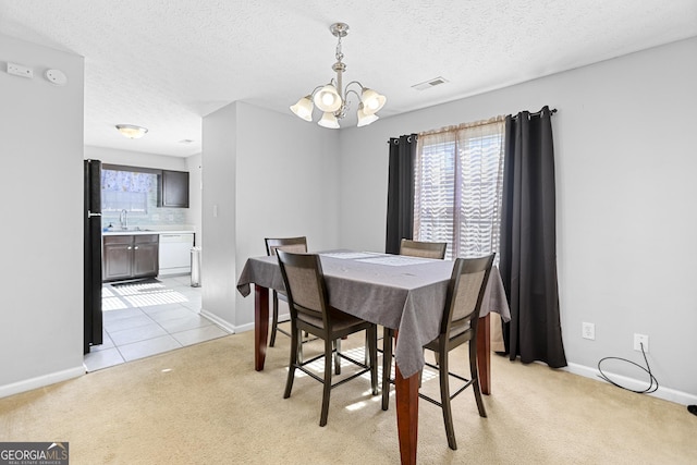 dining space with light colored carpet, a chandelier, and a textured ceiling