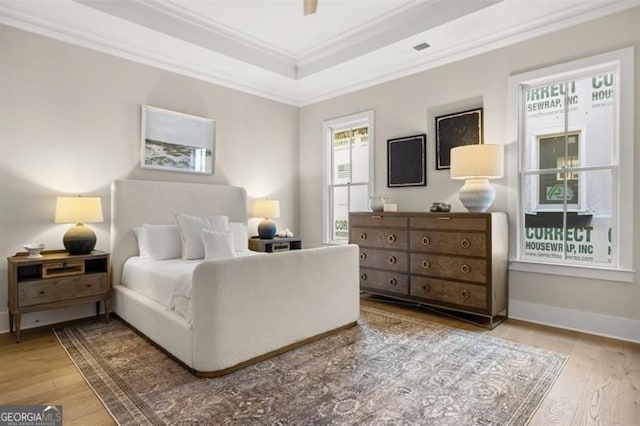 bedroom with ornamental molding, wood-type flooring, and multiple windows