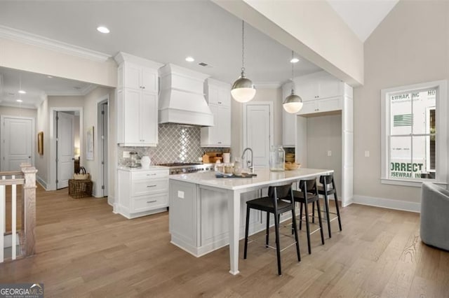 kitchen featuring ornamental molding, white cabinetry, decorative backsplash, and custom exhaust hood