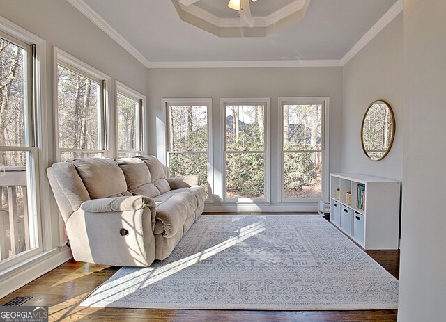 interior space featuring a tray ceiling, visible vents, ceiling fan, hardwood / wood-style flooring, and ornamental molding