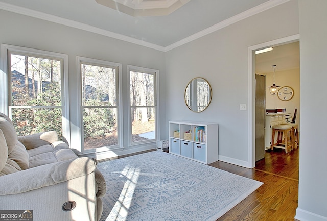 sitting room with plenty of natural light, ornamental molding, baseboards, and dark wood-style flooring