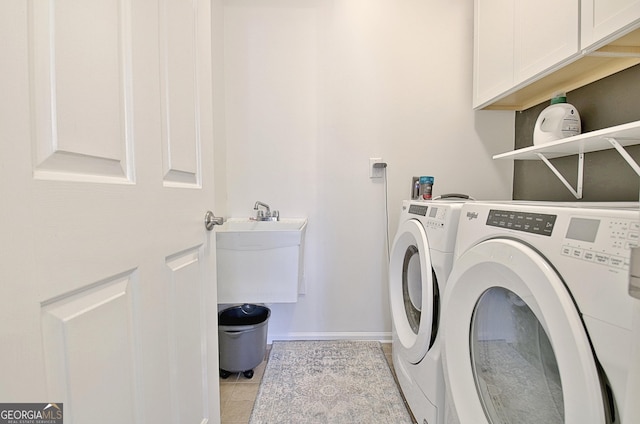 washroom with washing machine and clothes dryer, baseboards, light tile patterned floors, and cabinet space