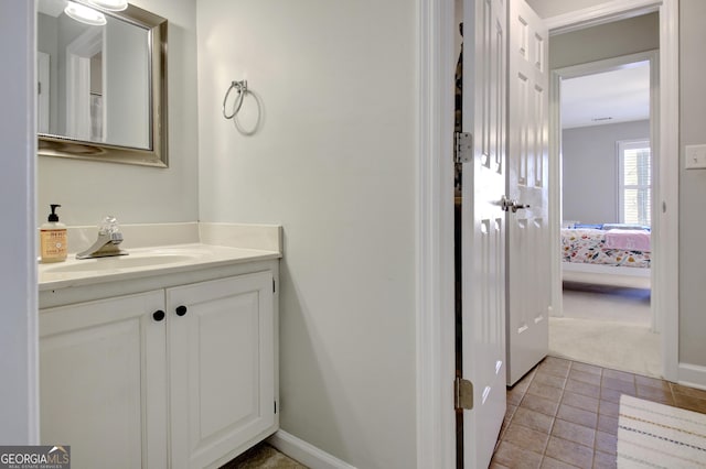 ensuite bathroom with baseboards, ensuite bath, tile patterned floors, and vanity