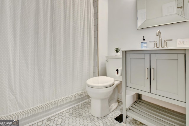 bathroom featuring a shower with shower curtain, toilet, and vanity