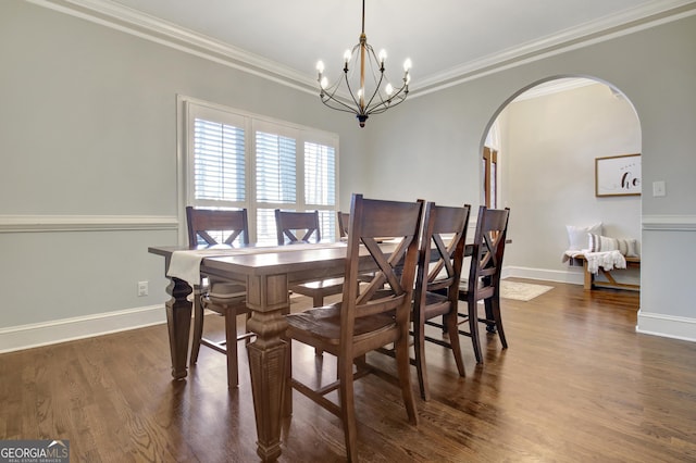 dining area with arched walkways, a chandelier, crown molding, and dark wood-style floors