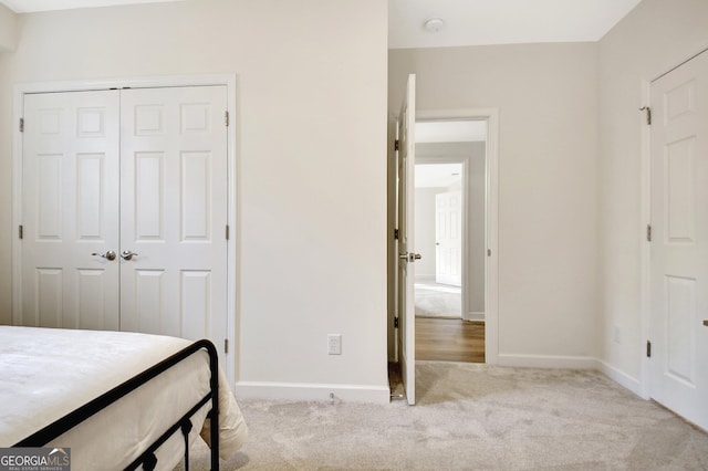 carpeted bedroom featuring baseboards and a closet