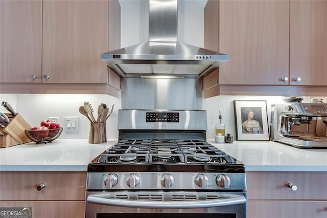 kitchen with gas stove and wall chimney range hood