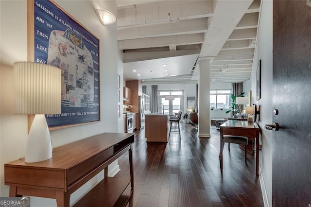 corridor featuring beam ceiling and dark hardwood / wood-style floors