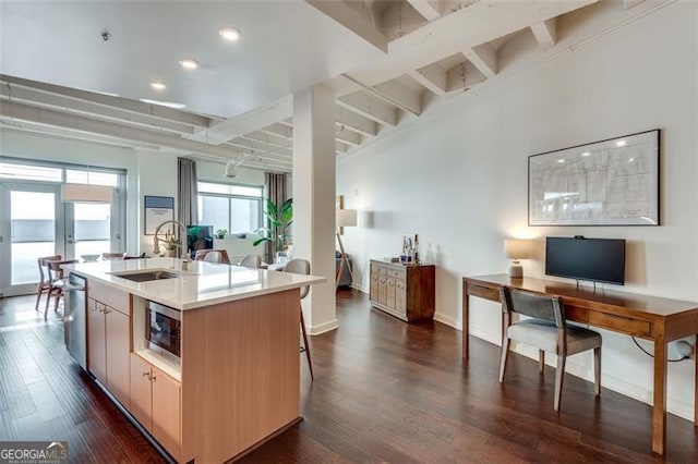 kitchen with sink, a center island with sink, dark hardwood / wood-style flooring, beamed ceiling, and stainless steel appliances